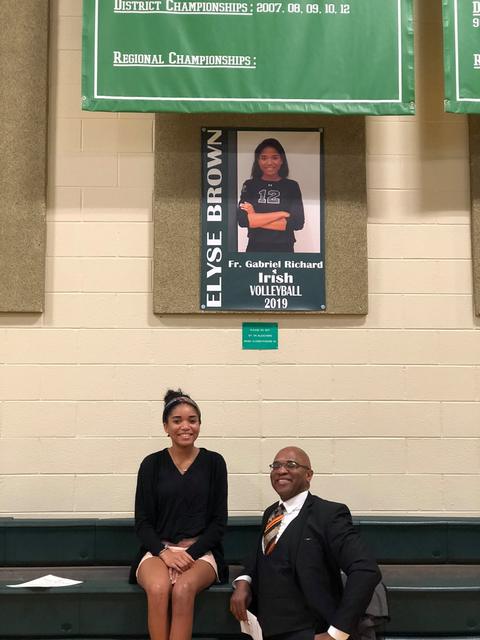 At a high school gym with a volleyball banner